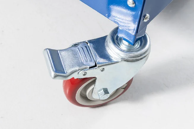 Nahaufnahme einer roten Lenkrolle mit Metallgabel und großem Feststellhebel.